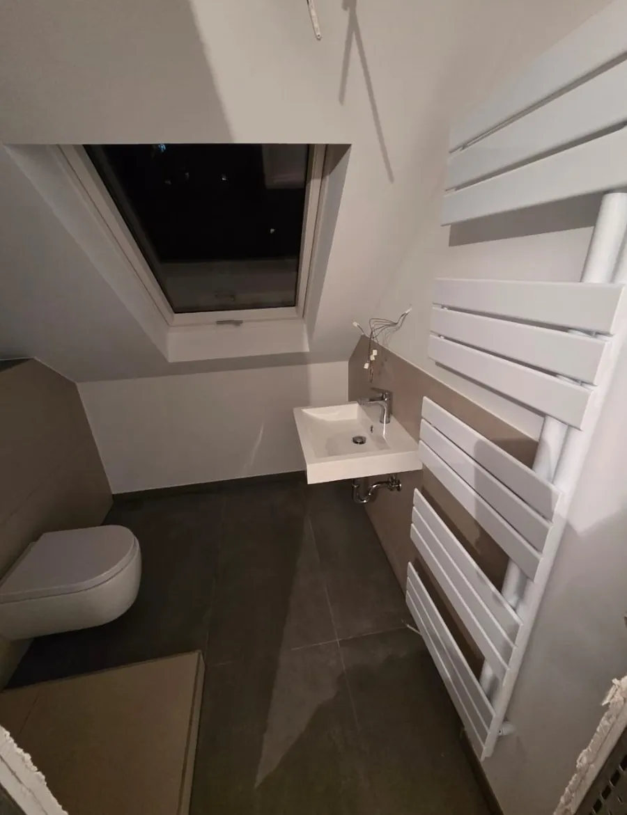 Fertiges Dachgeschossbad mit Wand-WC, Waschtisch und Design-Badheizkörper