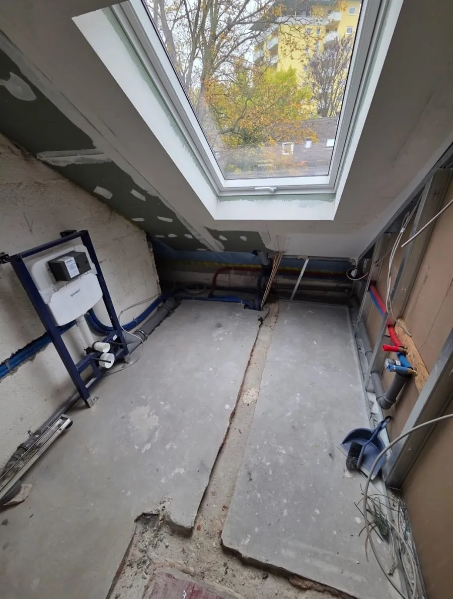 Dachgeschossbad im Rohbau mit montiertem WC-Vorwandelement und verlegten Leitungen